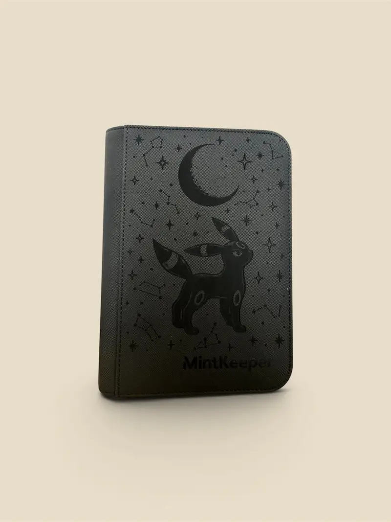 Black zip binder engraved in gold with an Umbreon-inspired figure seated under a crescent moon and stars. The cover is lettered Umbreon Under the Moon.